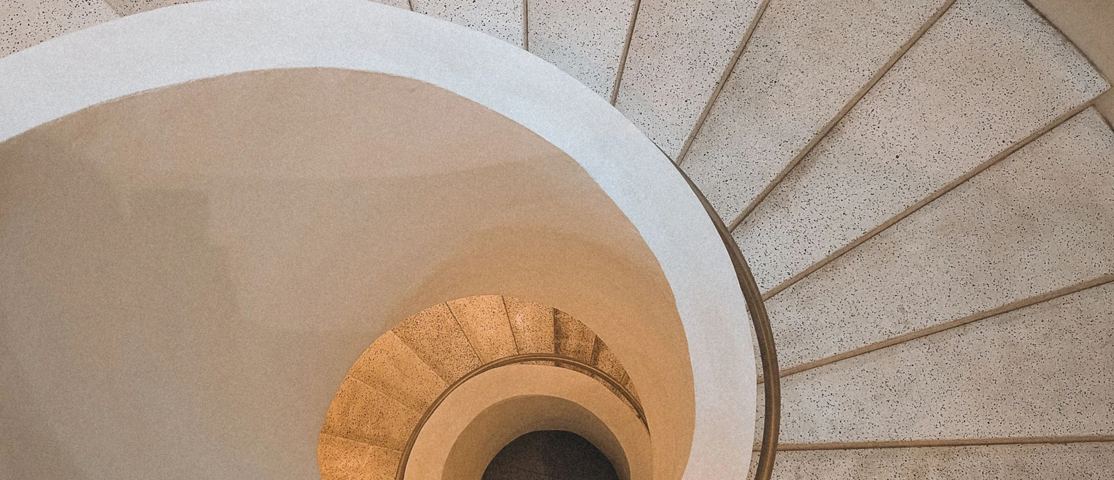 Courbe d’un escalier en pierre beige