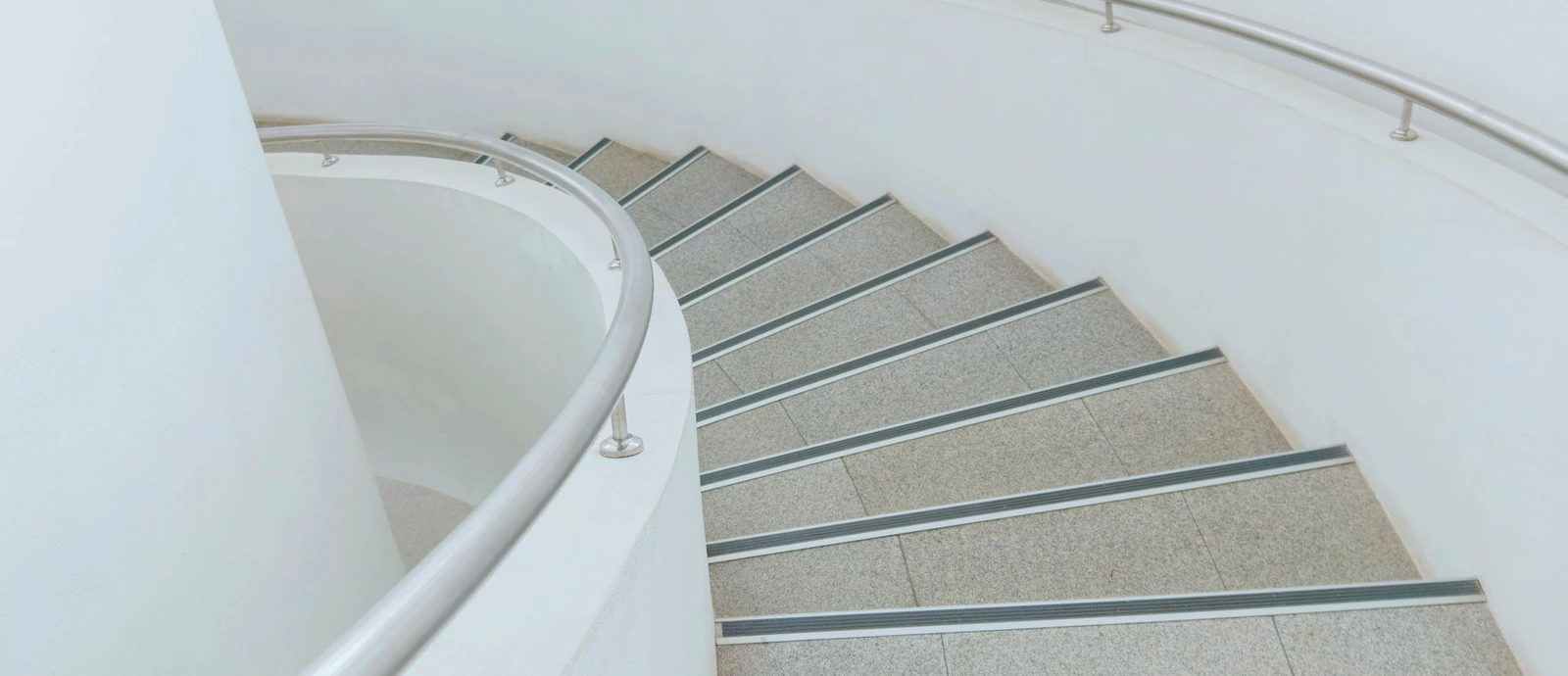 Détail d’un escalier courbe aux tons clairs